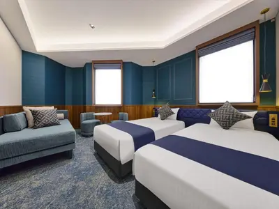 a hotel room with two beds and a couch at Villa Fontaine Tokyo Hibiya in Tokyo