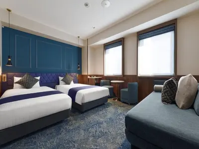 a hotel room with two beds and a couch at Villa Fontaine Tokyo Hibiya in Tokyo