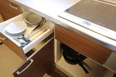 a kitchen with a counter with plates and utensils at \u6771\u4eac\u4e0b\u753a\u751f\u6d3b in Tokyo