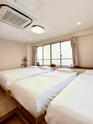 a row of beds in a room with windows at Ikeda Ueno 201 Quad Room in Tokyo