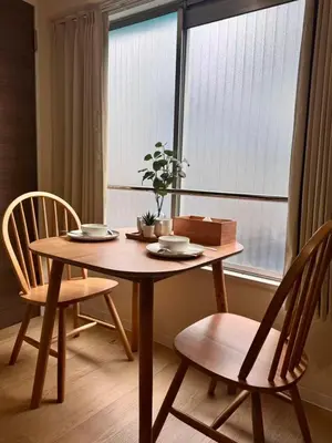 a wooden table with two chairs and a window at Ikeda Ueno 201 Quad Room in Tokyo