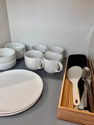 a table with white plates and cups and a wooden tray at Ikeda Ueno 201 Quad Room in Tokyo