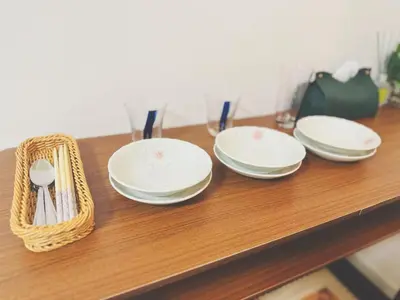 four white plates and a basket on a wooden table at 5min to\u65b0\u5bbfShinjuku in Tokyo