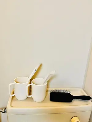 two cups and a brush on top of a drawer at 5min to\u65b0\u5bbfShinjuku in Tokyo