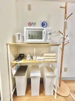 a microwave sitting on top of a shelf with trash cans at 5min to\u65b0\u5bbfShinjuku in Tokyo