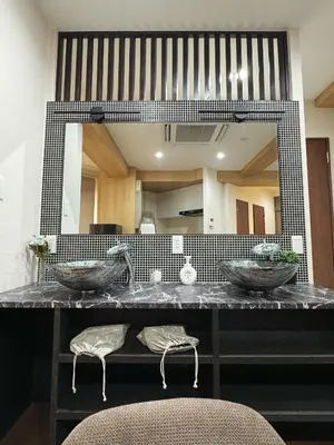 a bathroom with two sinks and a large mirror at OmOTeNaShI YAHIRO in Tokyo