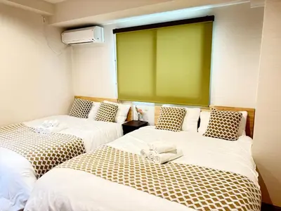 two beds in a room with a green screen at OmOTeNaShI YAHIRO in Tokyo