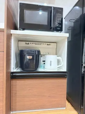 a microwave oven sitting on top of a refrigerator at OmOTeNaShI YAHIRO in Tokyo