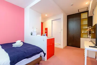 a bedroom with a bed and a desk with a computer at ViLLA SAKURA \u6771\u4eac\u76ee\u9ed2 in Tokyo