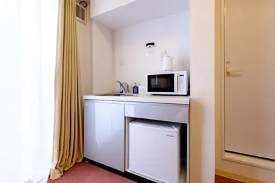 a hotel room with a microwave and a sink at ViLLA SAKURA \u6771\u4eac\u76ee\u9ed2 in Tokyo