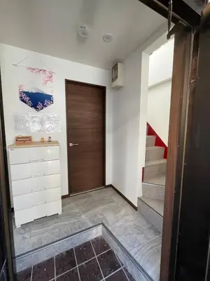 a hallway with a wooden door and stairs at Sweet House \u677f\u6a4b in Tokyo