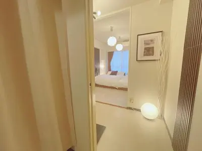 a hallway with a bedroom with a bed and a mirror at A cozy hidden gem in Ikebukuro in Tokyo