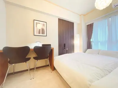 a bedroom with a bed and a desk with two chairs at A cozy hidden gem in Ikebukuro in Tokyo