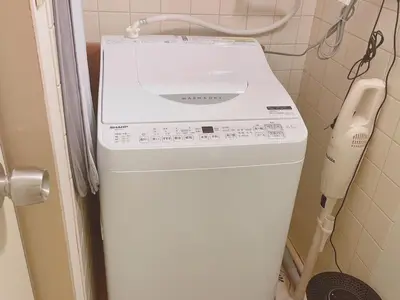 a white washer and dryer in a bathroom at A cozy hidden gem in Ikebukuro in Tokyo