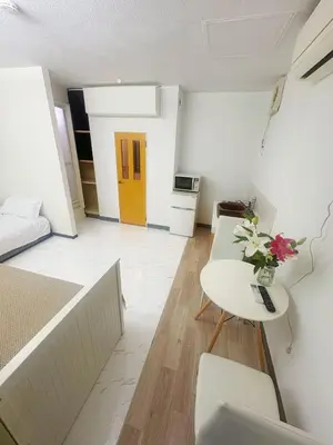 a living room with a table and a yellow door at Asakusa Sakura-1F in Tokyo