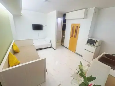 a small living room with a couch and a microwave at Asakusa Sakura-1F in Tokyo