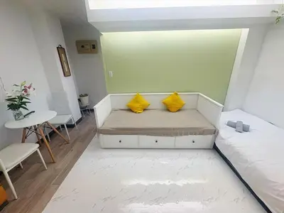a small room with a couch with two yellow pillows at Asakusa Sakura-1F in Tokyo