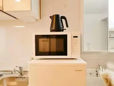 a microwave on top of a refrigerator with a kettle on top at Minami Ikebukuro APT Dear Cosmo Ikebukuro subway 6mins in Tokyo