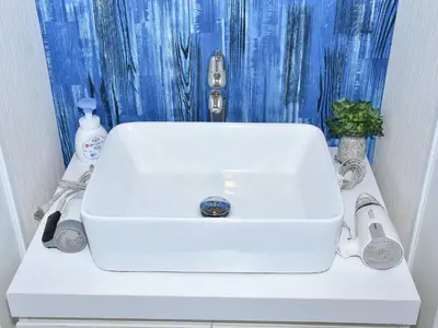 a white sink in a bathroom with a blue shower curtain at \u5bae\u5143in\u6d45\u8349\u96f7\u9580\u6d45\u8349\u5bfa\u305d\u3070\u306e\u4e00\u8ed2\u5bb6\u306e\u304a\u90e8\u5c4b1\u968e\u53c8\u306f2\u968e in Tokyo