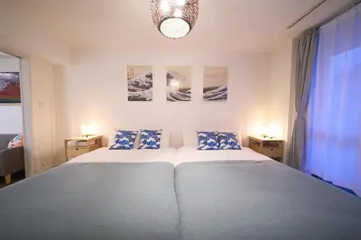 a bedroom with a large bed and two night stands at Lavi'n Asakusa ラヴィン浅草 in Tokyo