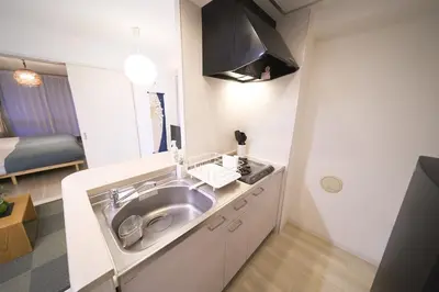 a small kitchen with a sink and a bedroom at Lavi'n Asakusa ラヴィン浅草 in Tokyo