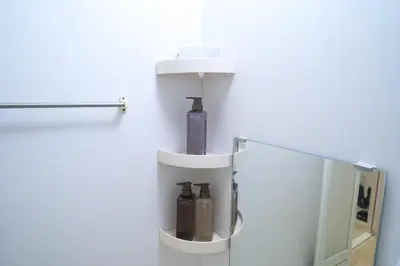 a bathroom with a mirror and a shelf with bottles at Lavi'n Asakusa ラヴィン浅草 in Tokyo