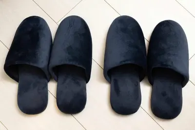three pairs of black suede shoes on a tile floor at \u30a2\u30f3\u30c9\u30b9\u30c6\u30a4\u5927\u68ee\u4e2d102 in Tokyo