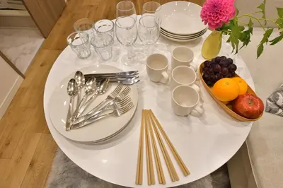 a white table with plates and silverware and a bowl of fruit at -Grandir Shibuya- 7-minute walk to Shibuya Station in Tokyo