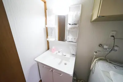 a bathroom with a white sink and a mirror at Yotsugi House \u56db\u30c4\u6728\u30cf\u30a6\u30b9 in Tokyo