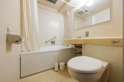 a white bathroom with a toilet and a sink at \u30d1\u30ec\u30b0\u30ec\u30a4\u30b9 in Tokyo