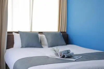 a bed with a tray with a book on it at \u30b9\u30de\u30fc\u30c8 ViLLA \u65d7\u306e\u53f0I\u756a\u9928 in Tokyo