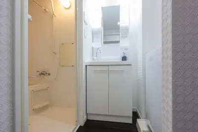 a white bathroom with a sink and a mirror at \u30b9\u30de\u30fc\u30c8 ViLLA \u65d7\u306e\u53f0I\u756a\u9928 in Tokyo