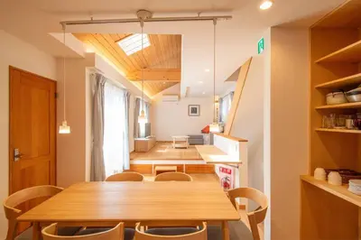 a dining room with a wooden table and chairs at \u3080\u304f\u306e\u5bb6 \u6d66\u5b89 in Tokyo