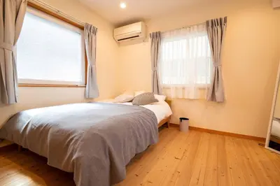 a bedroom with a bed and a large window at \u3080\u304f\u306e\u5bb6 \u6d66\u5b89 in Tokyo