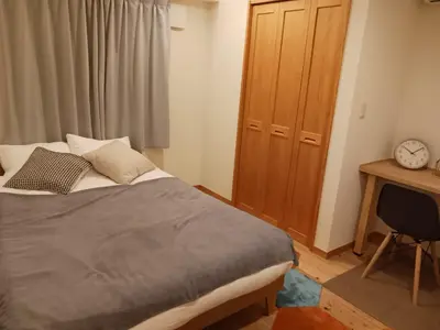 a bedroom with a bed and a wooden cabinet at \u3080\u304f\u306e\u5bb6 \u6d66\u5b89 in Tokyo