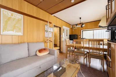 a living room with a couch and a dining room at \u30a2\u30f3\u30c9\u30b9\u30c6\u30a4\u9752\u62383\u4e01\u76ee in Tokyo