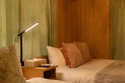 a bedroom with a bed with a lamp and a chair at \u30a2\u30f3\u30c9\u30b9\u30c6\u30a4\u9752\u62383\u4e01\u76ee in Tokyo