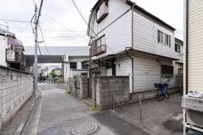 a house with a bike parked next to a street at \u30a2\u30f3\u30c9\u30b9\u30c6\u30a4\u9752\u62383\u4e01\u76ee in Tokyo