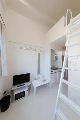 a white living room with a ladder and a television at monthly Nano Kamiochiai in Tokyo