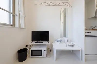 a white kitchen with a tv and a microwave at monthly Nano Kamiochiai in Tokyo