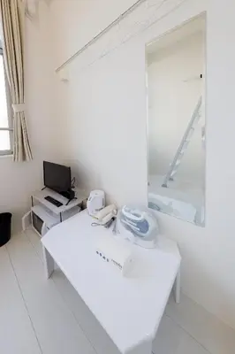 a white room with a mirror and a white table at monthly Nano Kamiochiai in Tokyo