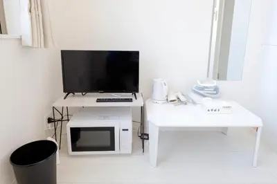 a white desk with a tv and a microwave at monthly Nano Kamiochiai in Tokyo