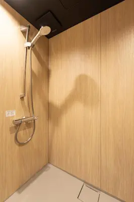 a shower in a bathroom with a wooden wall at \u548c\u8239 wafune in Tokyo