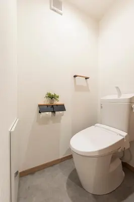 a white bathroom with a toilet and a plant at \u548c\u8239 wafune in Tokyo