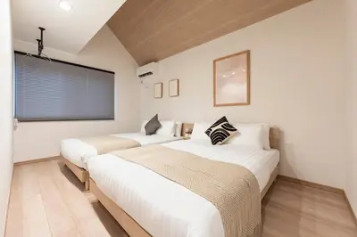 two beds in a room with white walls and a window at \u548c\u8239 wafune in Tokyo