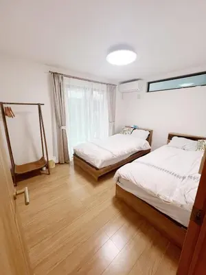 a bedroom with two beds and a window at \u6771\u4eac\u82b3\u83ef\u9a7f\u9986 in Tokyo