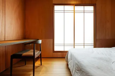 a bedroom with a bed and a desk and a window at Yohaku Tokyo in Tokyo