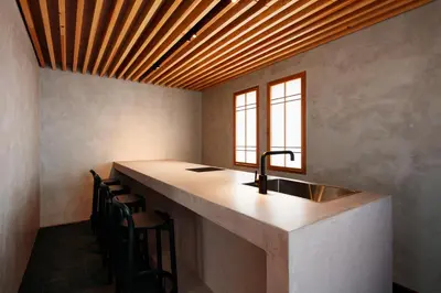 a kitchen with a counter with a sink and chairs at Yohaku Tokyo in Tokyo