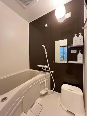 a bathroom with a white toilet and a bath tub at nestay suite tokyo skytree in Tokyo