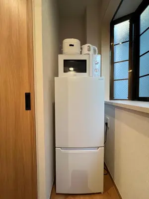 a white refrigerator with a microwave on top of it at nestay suite tokyo skytree in Tokyo